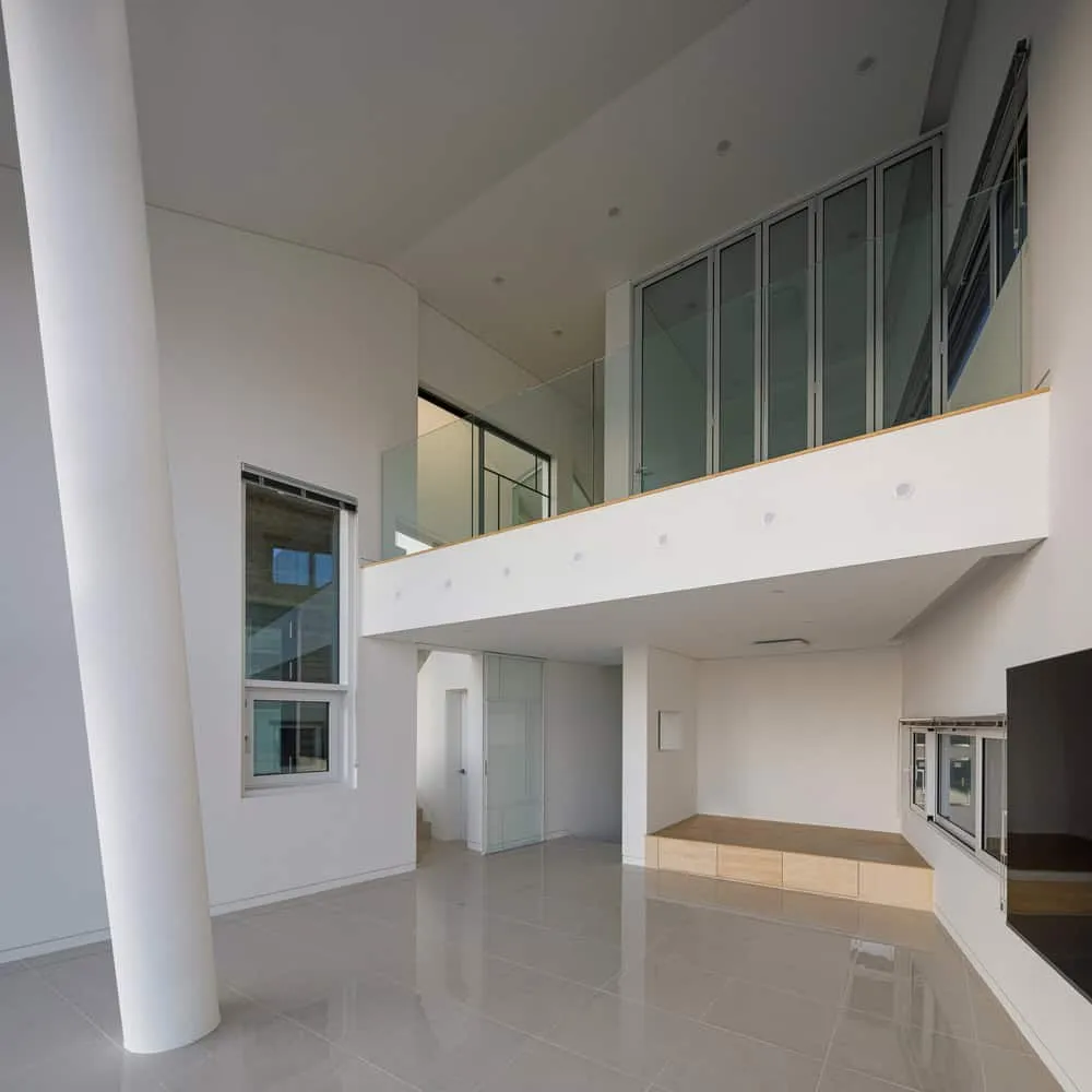 Pacific Residence Double Height Living Space by Moon Hoon Der doppelt hohe Wohnbereich des Pacific Residence von Moon Hoon mit Balkon in Seogwipo