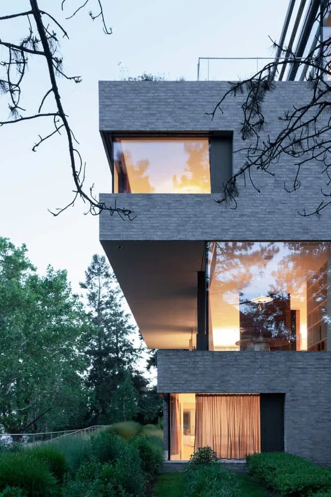 Villa Vista – abendlicher Überhanggartenrand von Znameni Ctyr Architekti Villa Vista von Znameni Ctyr Architekti, dramatischer abendlicher Überhang über dicht bepflanzten Garten