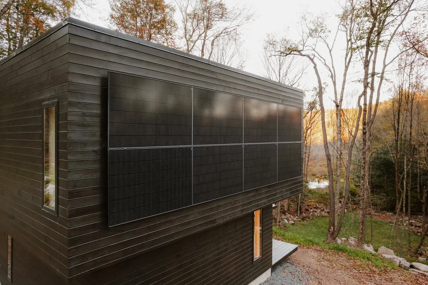 Solarfassade des Forest Edge House von Marc Thorpe Design Nahaufnahme der Fassade des Forest Edge House mit integrierten Solarmodulen im Wald in New York