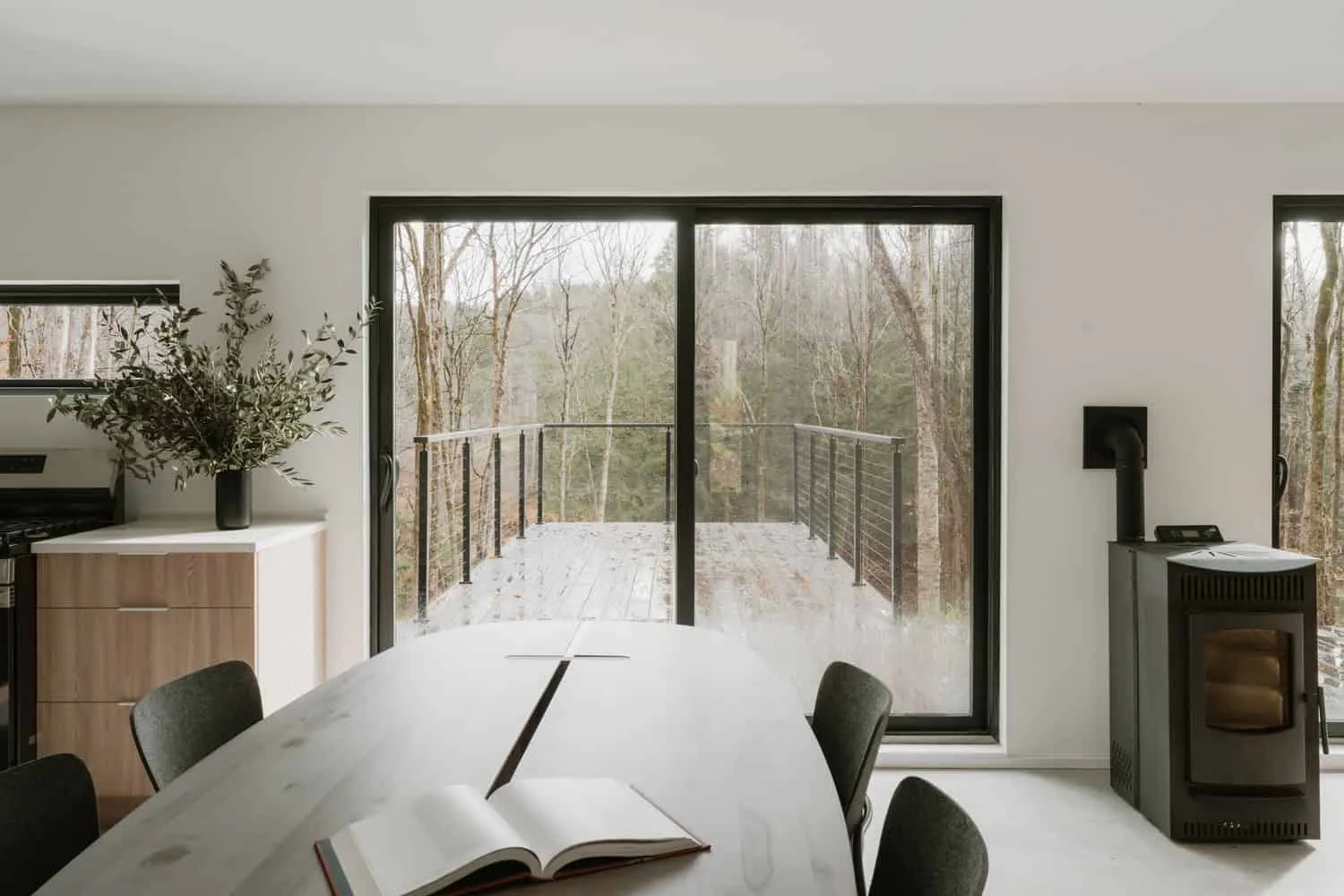 Esszimmer des Forest Edge House von Marc Thorpe Design Ess- und Küchenbereich im Forest Edge House mit Ausblick auf eine Waldterrasse in New York