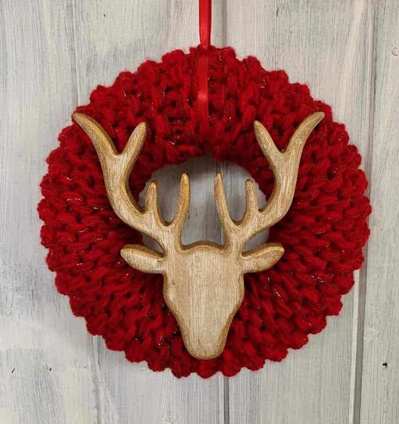 Roter gestrickter Weihnachtskranz mit Holzrentier Roter gestrickter Weihnachtskranz mit Holzrentier-Ornament