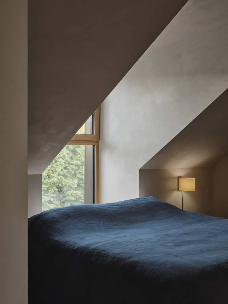 Dachgeschossschlafzimmer in Maison Melba mit schrägem Dach und Fenster von Atelier L’Abri Dachgeschossschlafzimmer von Maison Melba von Atelier L’Abri mit schrägem Dach und großem Eckfenster in Frelighsburg, Quebec