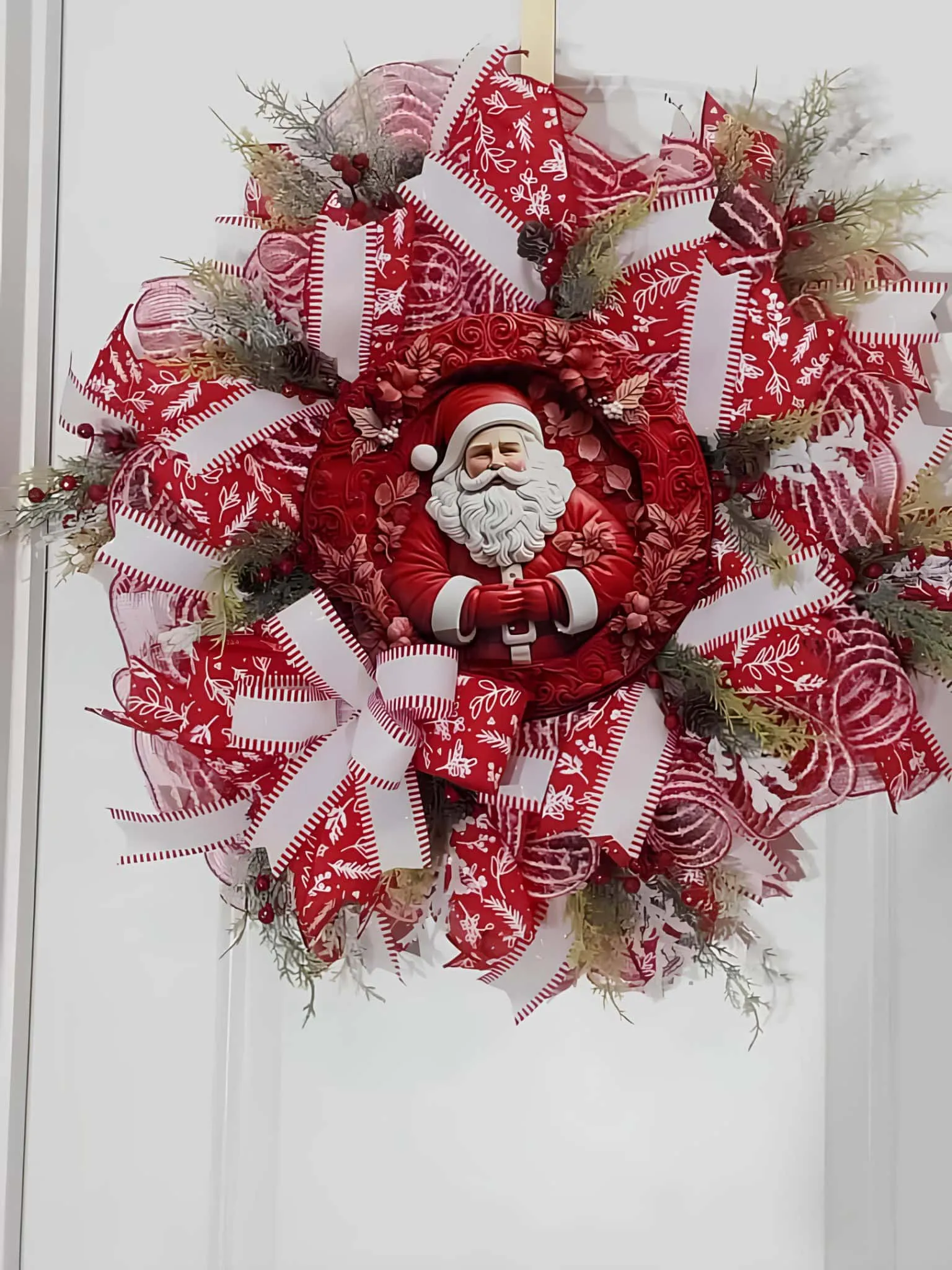 Kranz mit roter Schleife als Mittelpunkt für den Weihnachtsmann Schichtweiser Kranz aus roter Schleife mit Weihnachtsmann-Mittelpunkt und winterlichen Zweigen
