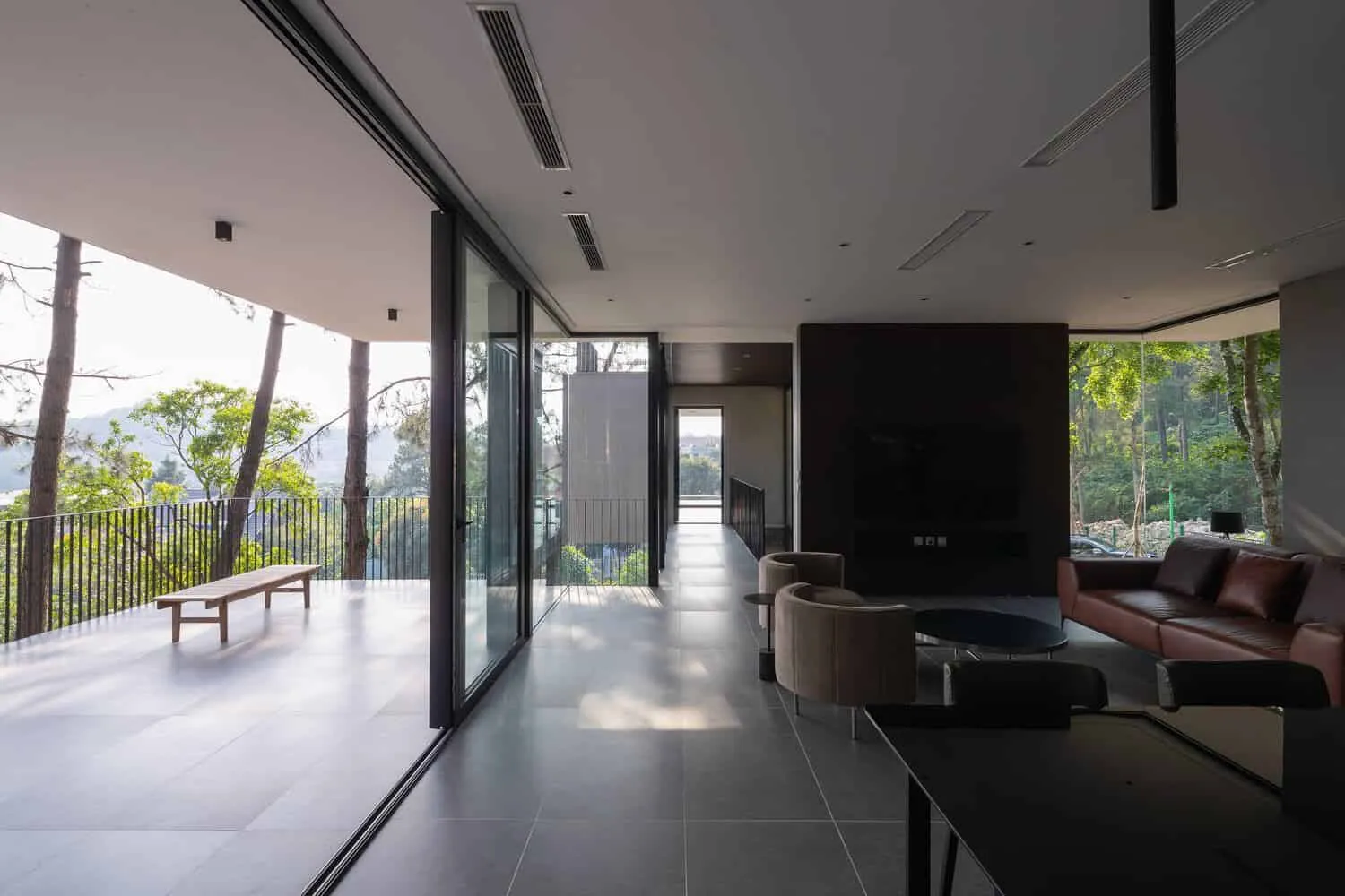 Verbindung zwischen Wohnzimmer und Terrasse des Tam Dao Retreat House von Idee architects Wohnzimmer des Tam Dao Retreat House von Idee architects, das mit einer großen Terrasse in Tam Dao, Vietnam, verbunden ist