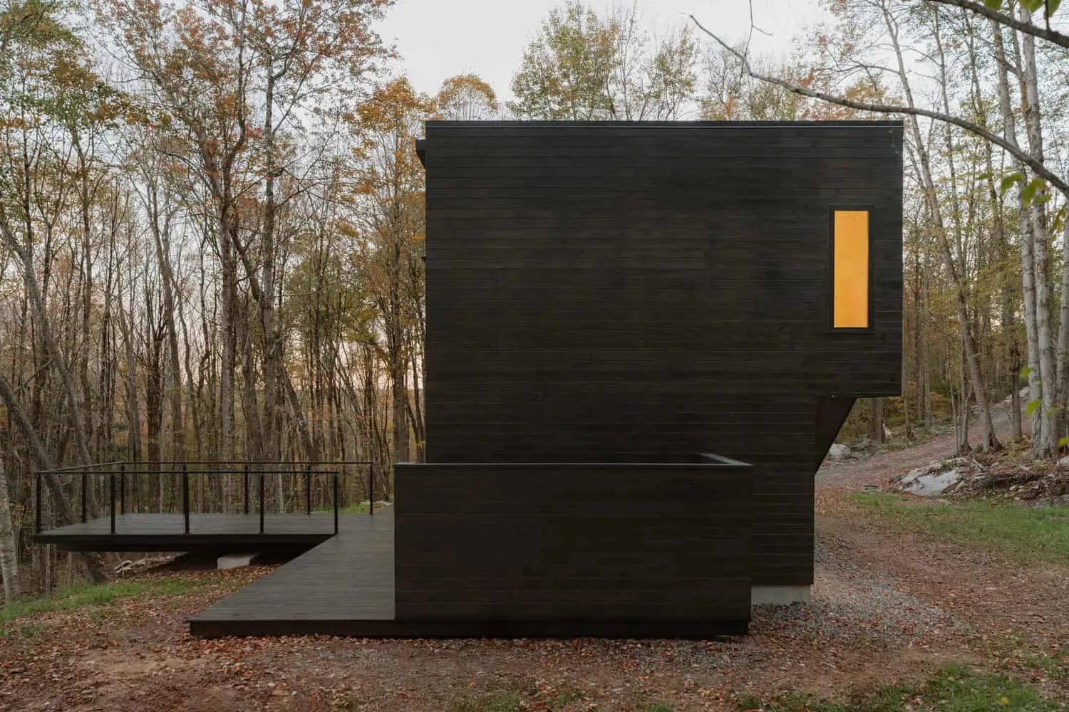 Sideansicht des Forest Edge House mit überstehender Terrasse im Wald in New York von Marc Thorpe Design Seitliche Ansicht des Forest Edge House mit überstehender Terrasse im Wald in New York