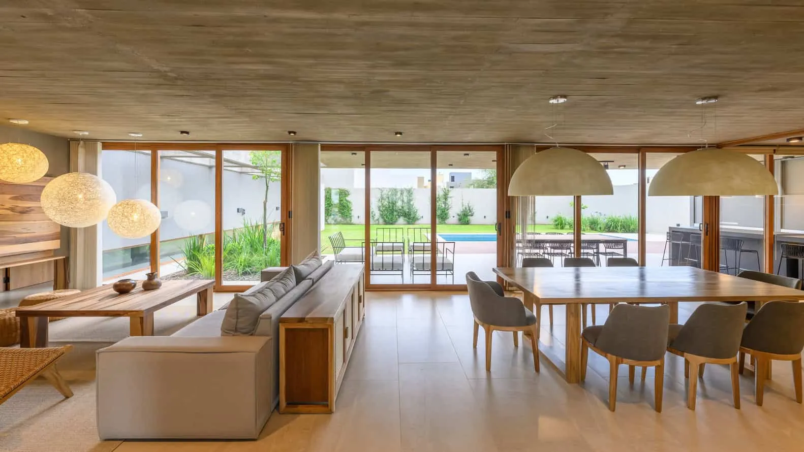 Haus G von Karlen + Clemente – Lounge- und Essbereich mit Ausblick auf den Garten, Río Tercero
