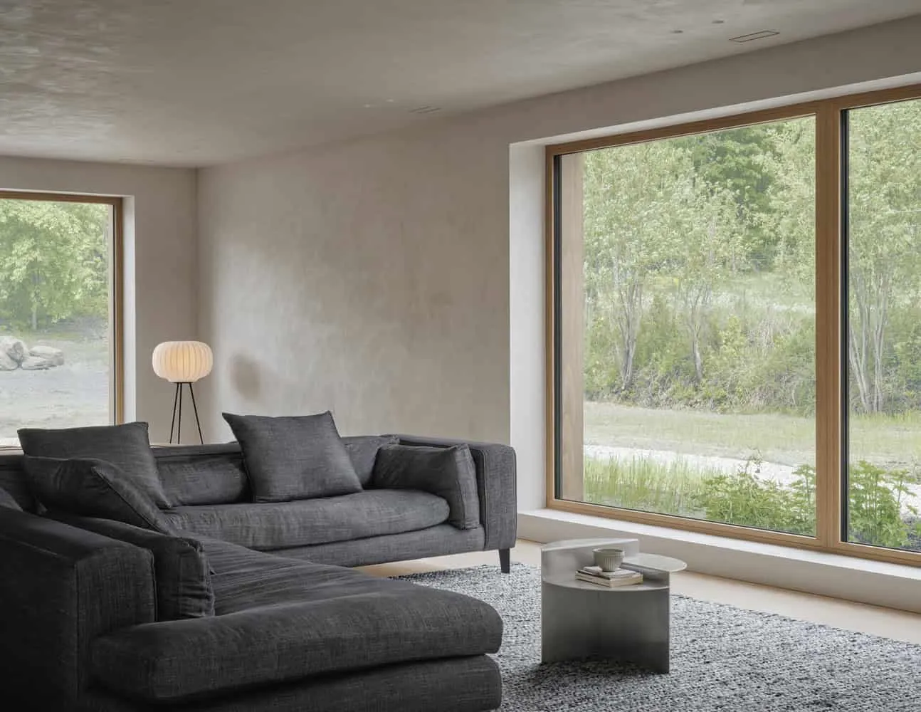 Fenster und Stehlampe im Wohnzimmer von Maison Melba von Atelier L’Abri Wohnzimmer von Maison Melba von Atelier L’Abri mit großem Fenster, Sitzbereich und skulpturaler Stehlampe in Frelighsburg, Quebec