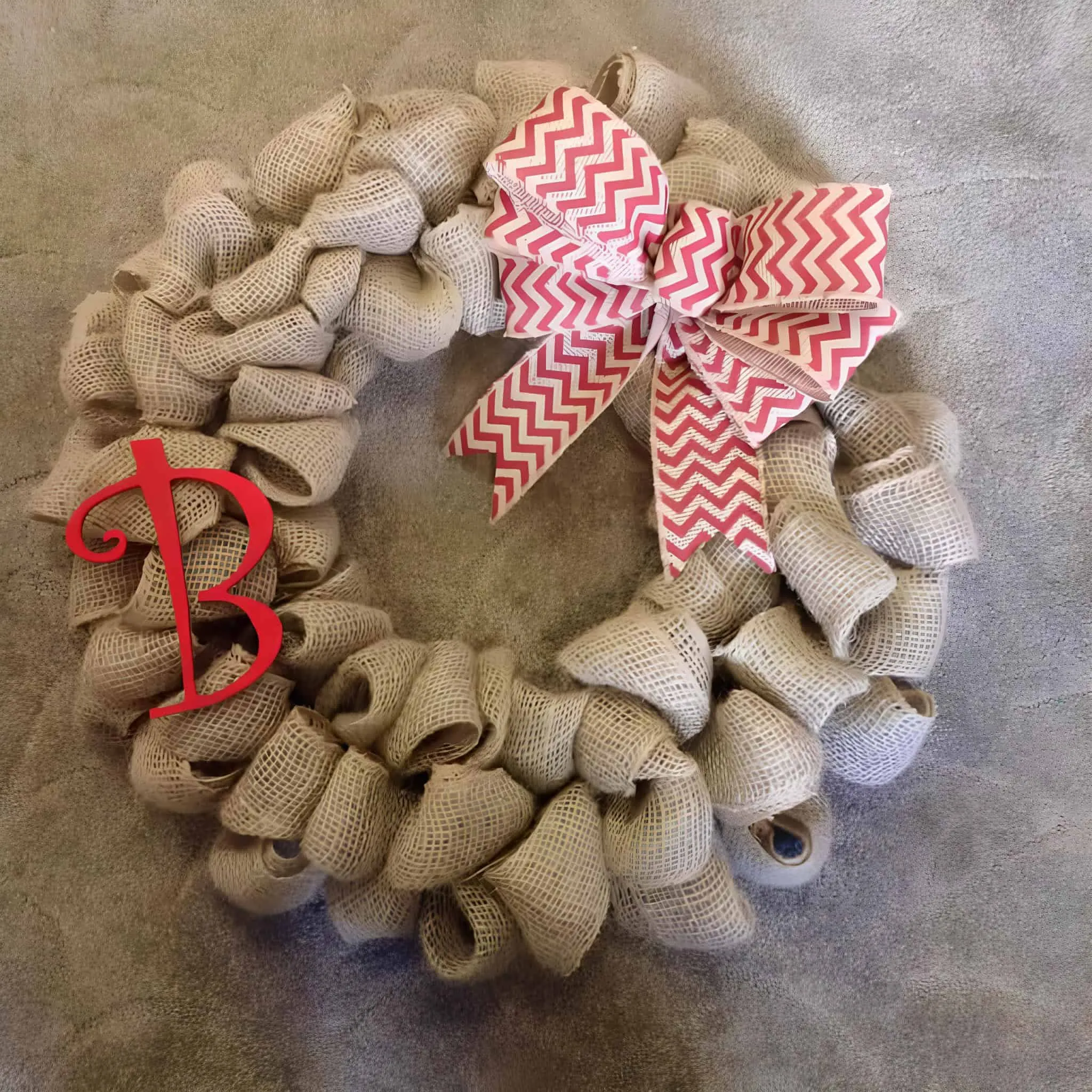 Weihnachtskranz aus Jutestreifen Rustikaler Weihnachtskranz aus Jute mit roter Chevronschleife und Monogramm
