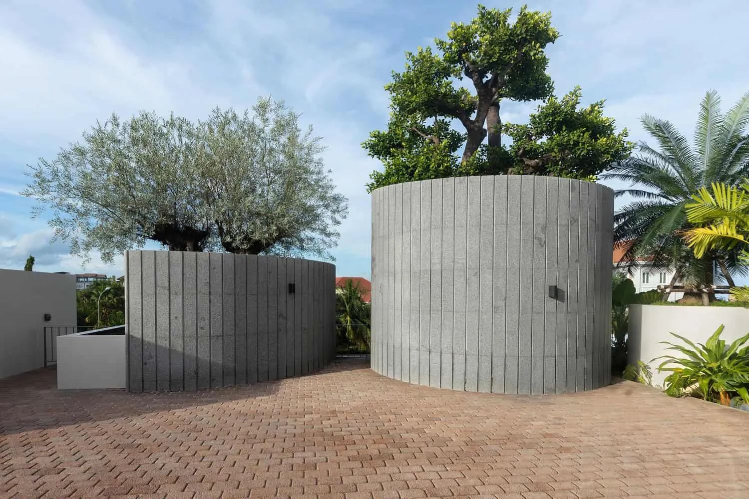 Zylindrische Pflanzkübel und Olivenbäume auf dem Dach der Wat Bo House von UAD Architects Dachterrasse der Wat Bo House von UAD Architects mit zylindrischen Steinpflanzkübeln und Bäumen in Kambodscha
