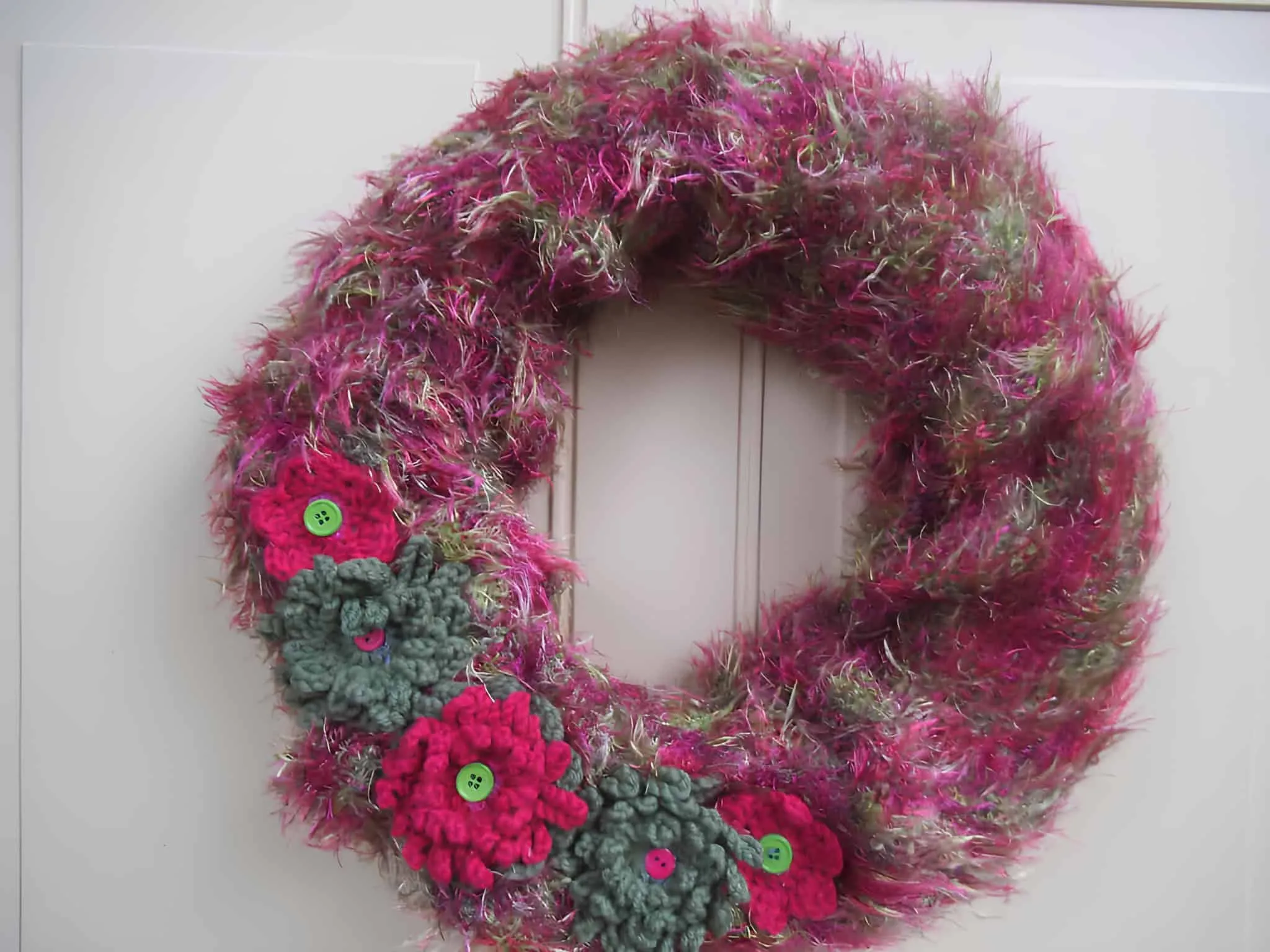 Fuzzy Yarn Floral Christmas Wreath Handgemachte Weihnachtskrone aus flauschigem Garn, verziert mit gehäkelten Blumen und Knöpfen
