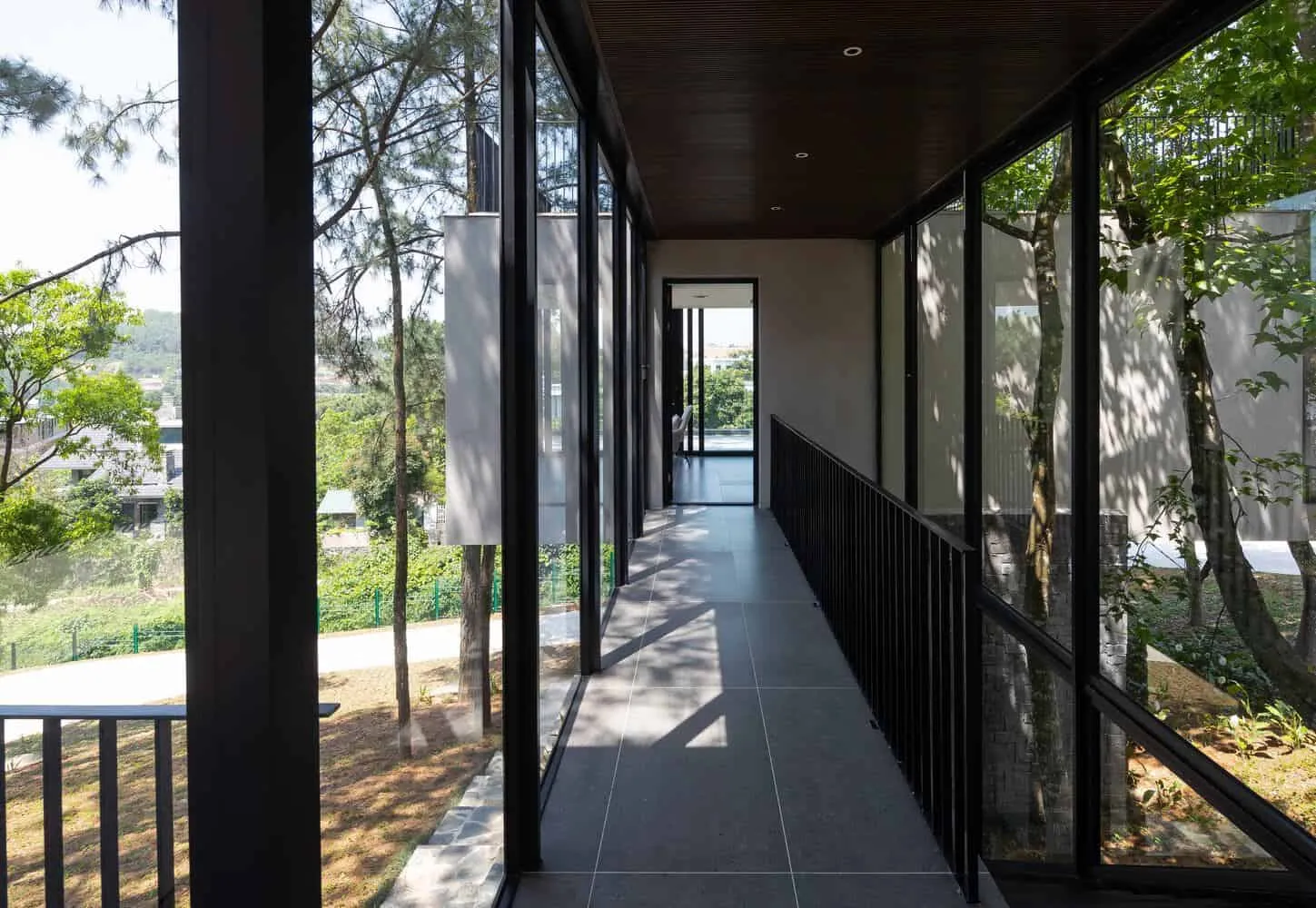 Glaskorridor des Rückzugshauses in Tam Dao von Idee architects Glaskorridor des Rückzugshauses in Tam Dao von Idee architects mit Blick auf den Wald in Tam Dao, Vietnam