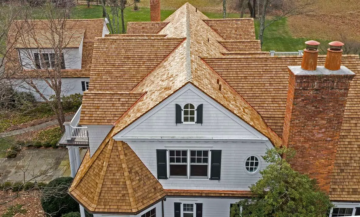 Wood Shingles and Shakes – Natural Warmth and Texture Rustic cottage with cedar wood shake roof—natural, warm, and eco-friendly roofing with handcrafted texture