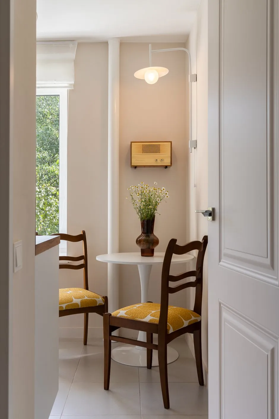 Intérieur minimaliste de cuisine et de salle à manger. Une éclairage professionnel met en valeur la texture du bois ainsi que les formes épurées des meubles.